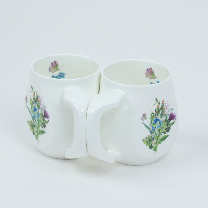 Two white fine bone china mugs with a colourful butterfly printed on the side.